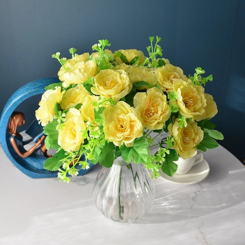 Artificial silk rose bouquet with 7 yellow tea roses and green leaves in clear vase