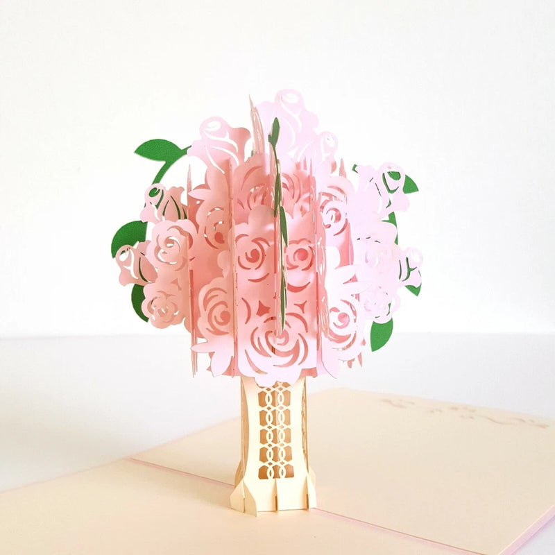 Pink pop-up rose flower greeting card, open with layered petals and green leaves