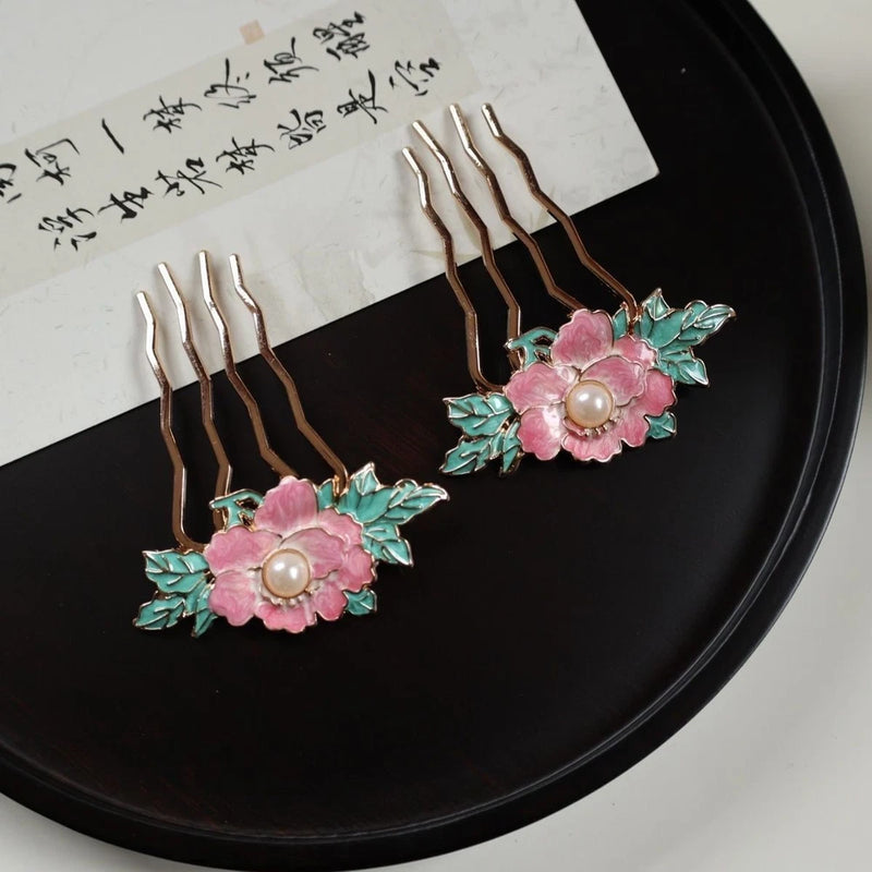 Peony flower hair comb with pink petals, teal leaves, and a pearl center on metal tines