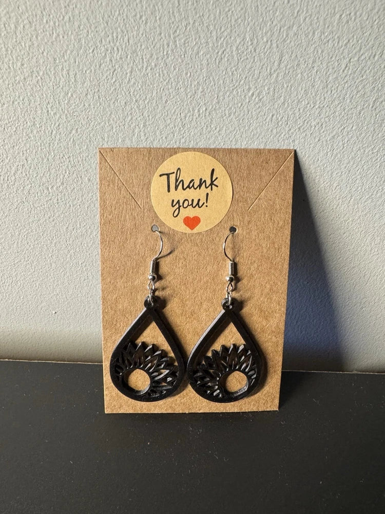 Black resin drop earrings with sunflower medallion in teardrop setting, fishhook backs