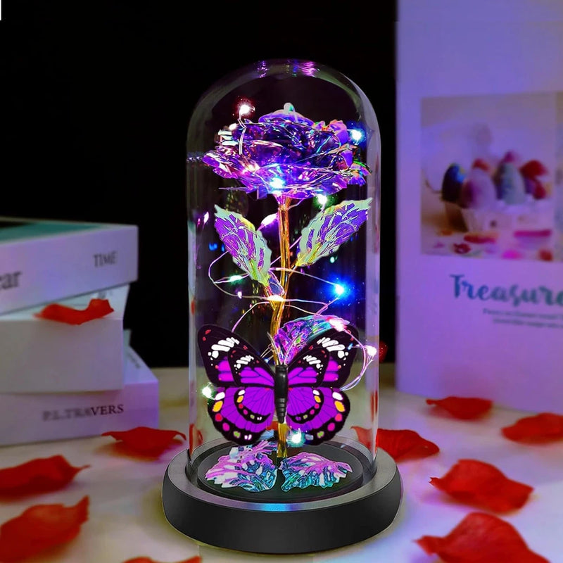 Illuminated purple rose under glass dome with butterfly accents and multicolor lights, black base