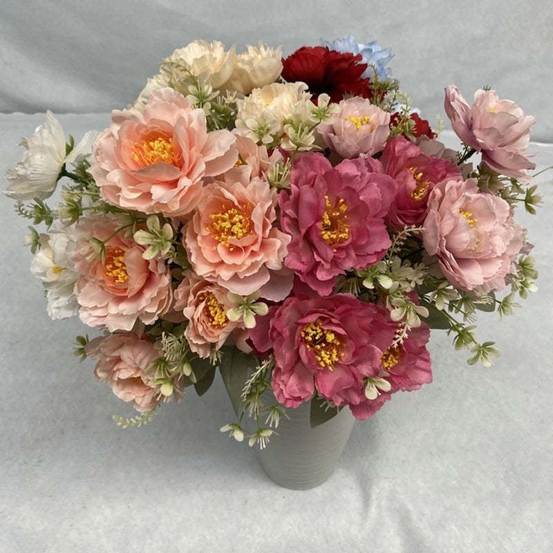 Artificial peony bouquet with pink, cream, and red peony flowers and greenery in a gray vase