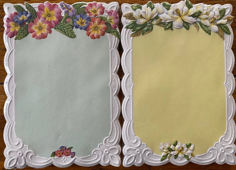 Die-cut bouquet notepad with embossed white floral borders and two colored memo pages