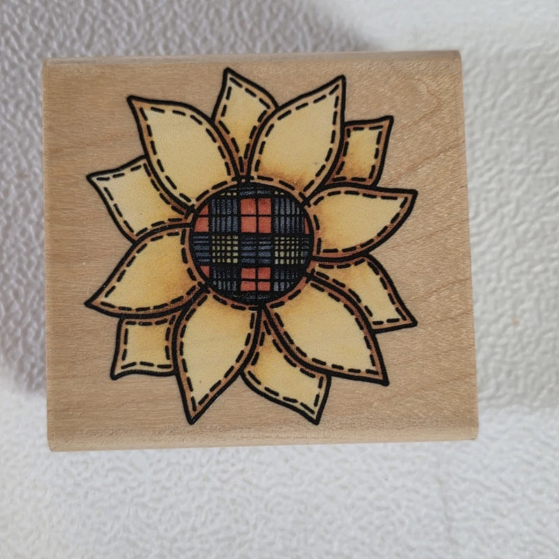 Sunflower rubber stamp with stitched petals and plaid center on wooden block