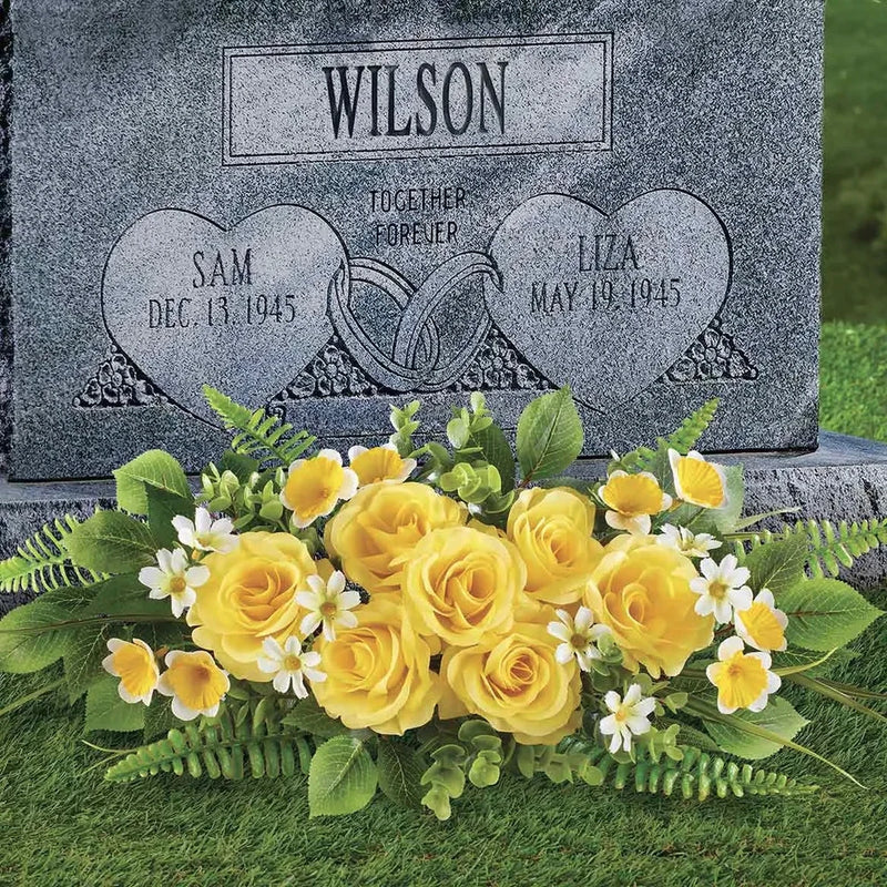 Artificial yellow rose memorial arrangement with green leaves and white blooms