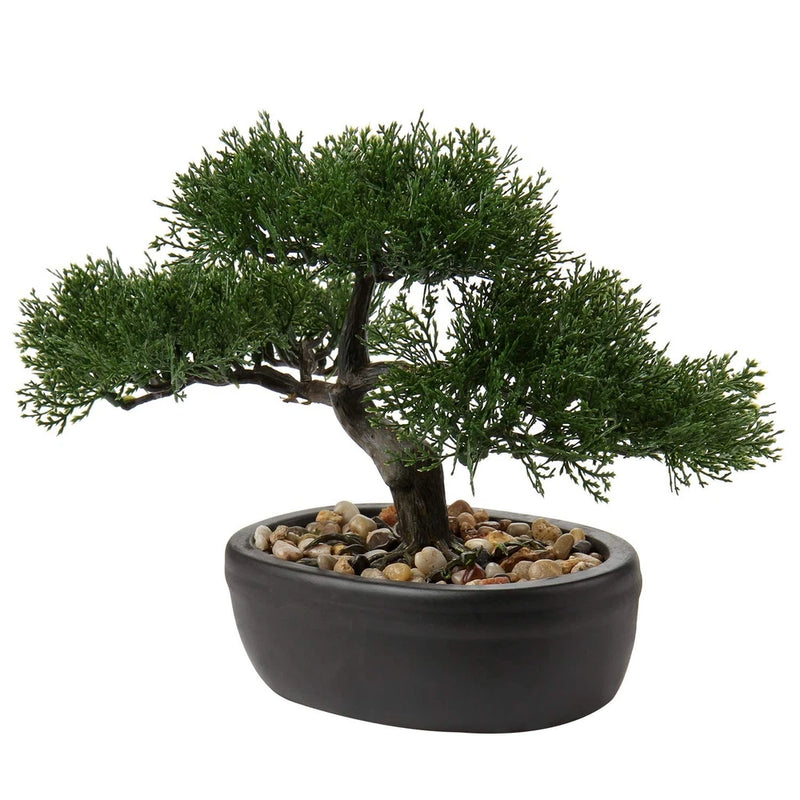 Small artificial bonsai tree with dark green foliage in dark matte pot with stones