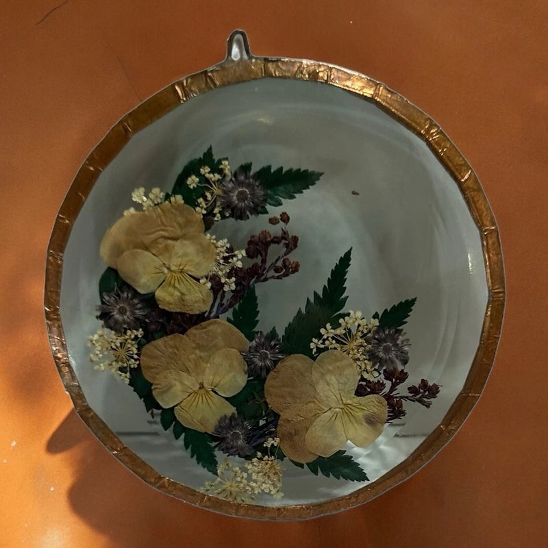 Round copper-framed dried flower glass wall art with gold and purple blooms