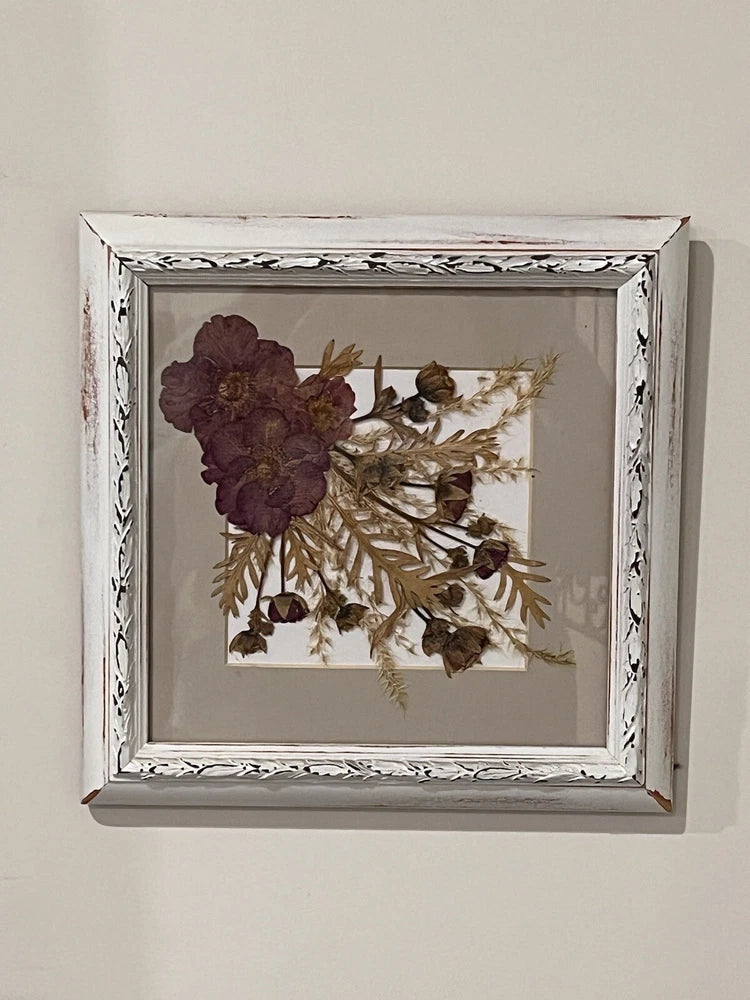 White wood-framed pressed dried flowers and leaves with burgundy bloom