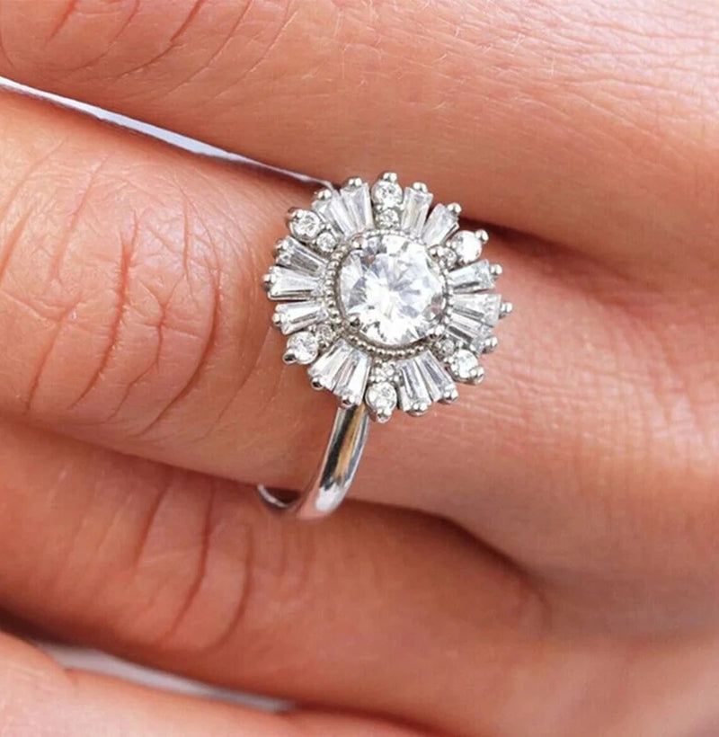 Moissanite engagement ring with round center stone and sunflower halo