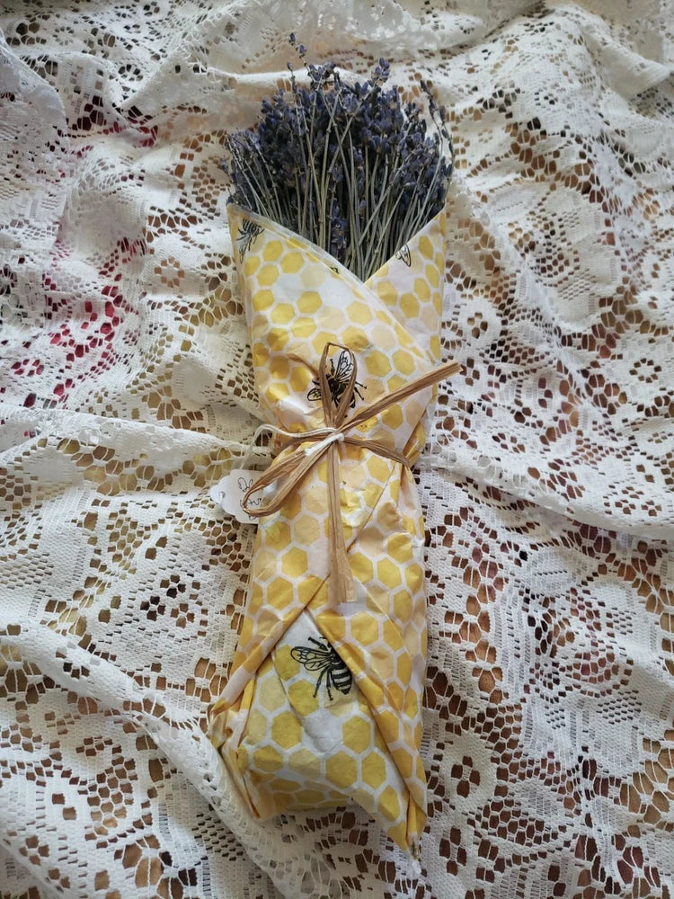 Dried lavender bundle wrapped in yellow honeycomb tissue with bee motif ribbon tie