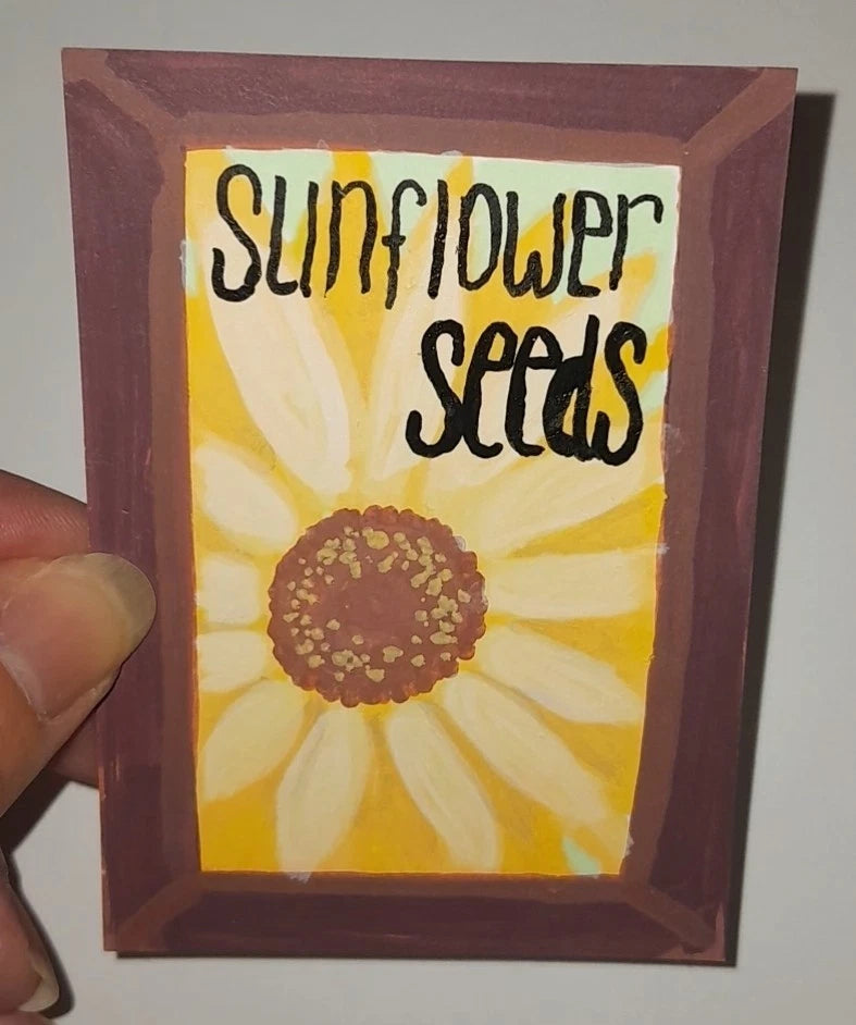 Framed sunflower acrylic painting with bold text 'SUNFLOWER SEEDS'.