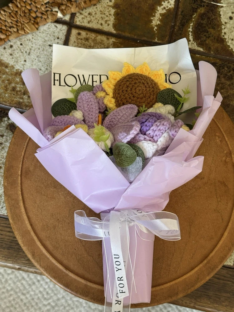 Handmade crochet sunflower bouquet with pink and purple flowers, green leaves, wrapped in ribbon