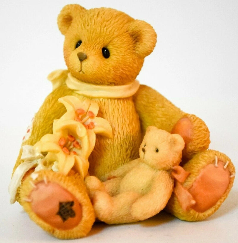 Stuffed plush teddy bear in orange-brown holding flower bouquet and small bear plush