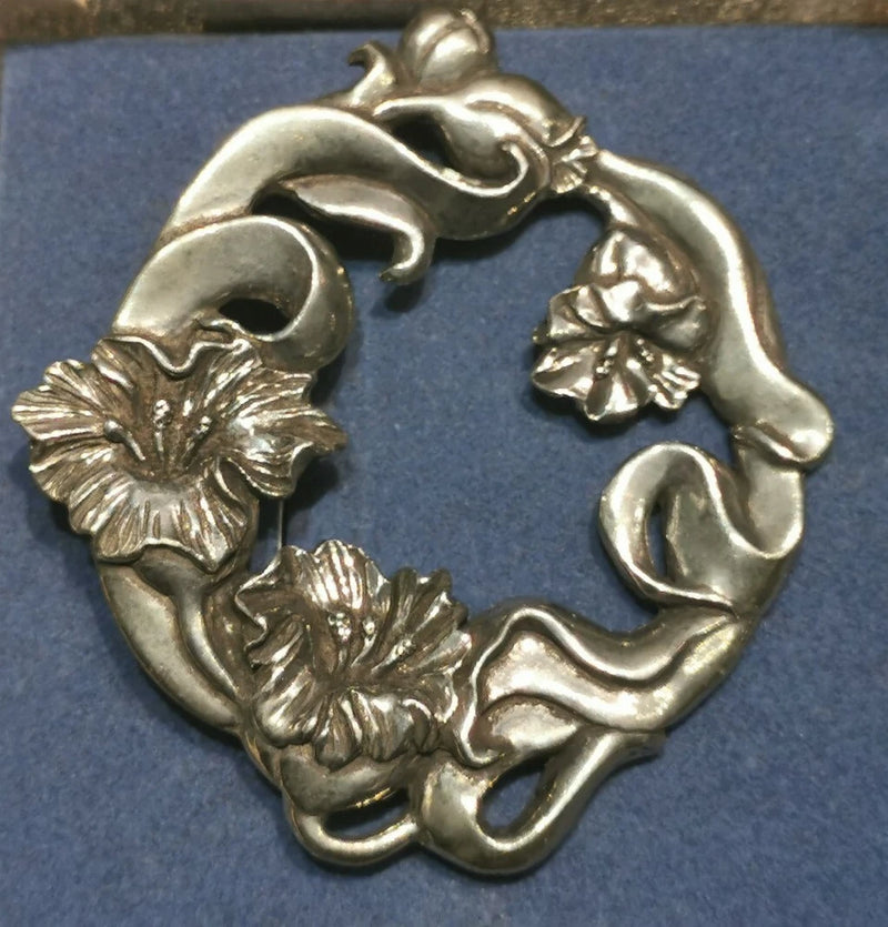 Pewter-tone lily flower brooch pin with leaves, circular wreath design