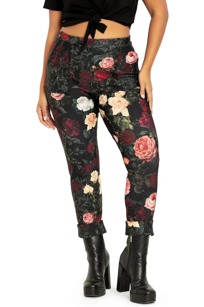 Cuffed rose-print pants, dark floral pattern on black fabric