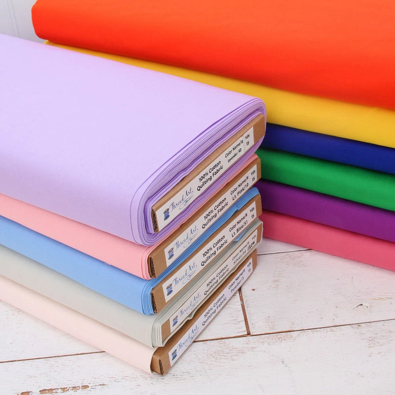 Cotton quilting fabric bundle, solid colors stack: purple, pink, blue, green, yellow, orange.