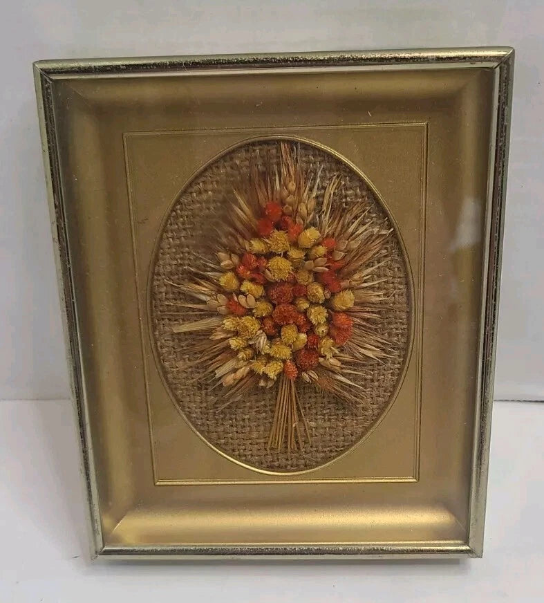 Framed dried floral wall hanging with oval yellow-orange flower bundle, gold border