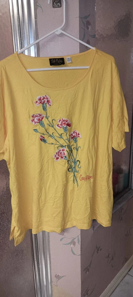 Yellow cotton top with embroidered pink and purple flowers at the chest