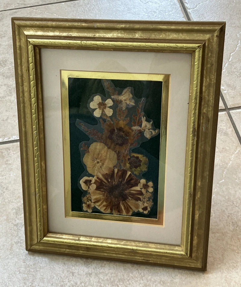 Vintage gold framed pressed flower bouquet under glass
