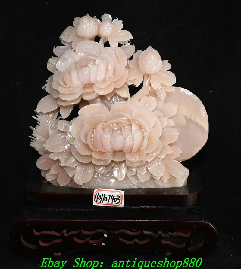 Pale pink carved peony flower statue with layered blossoms on dark base