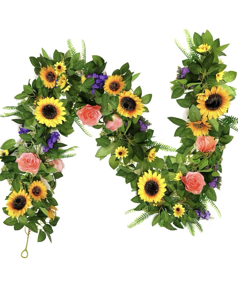Faux sunflower flower garland with green leaves, pink roses, and purple blooms
