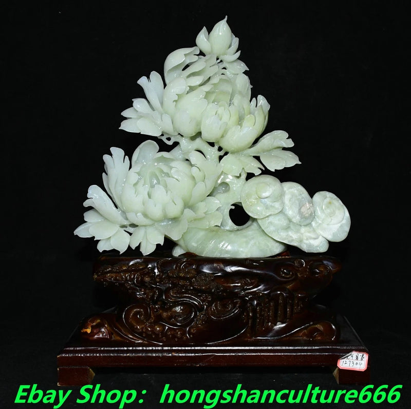 Carved light green jade peony ruyi statue on dark brown ornate base