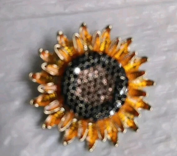Glitter sunflower brooch pin with dark beaded center and orange-gold petal border