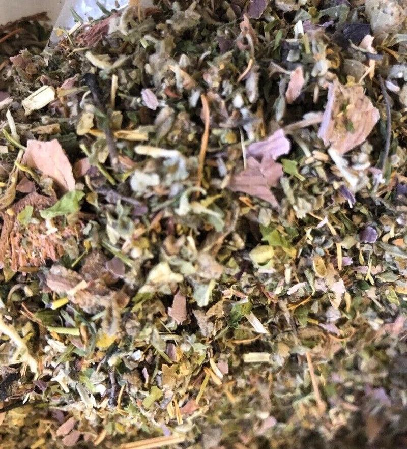 Dried herbal flower blend with purple and pink petals, green leaves, and brown stems