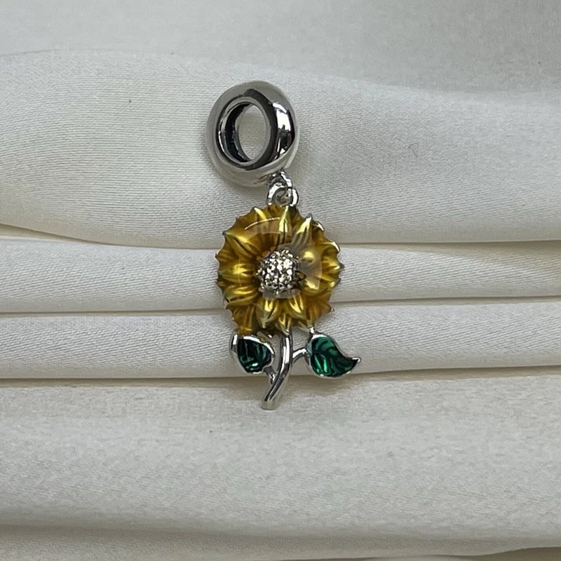 Sunflower dangle charm with gold enamel petals, clear cubic zirconia center, green leaves