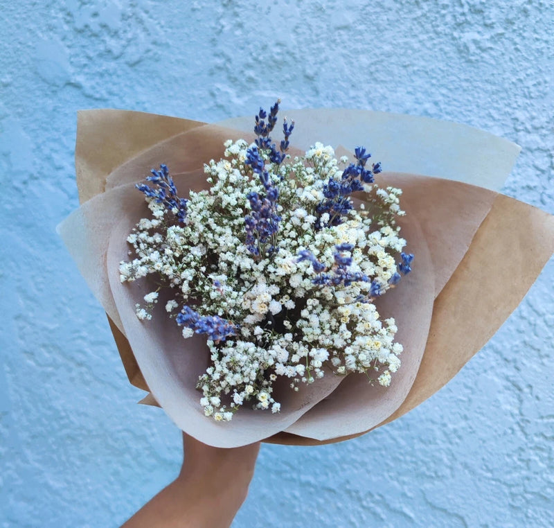 Dried lavender and baby’s breath bouquet with purple-blue and white blooms wrapped in kraft