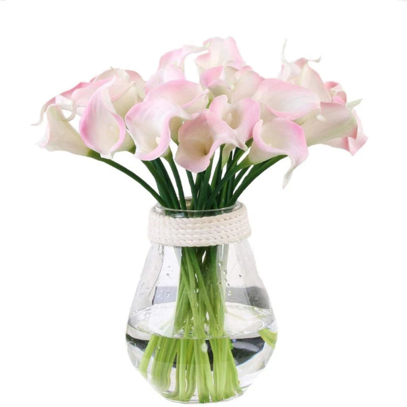 Artificial pink calla lily bunch in clear glass vase with woven ribbon wrap