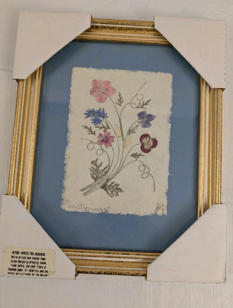 Gold-framed pressed wildflower art with pink and purple blooms