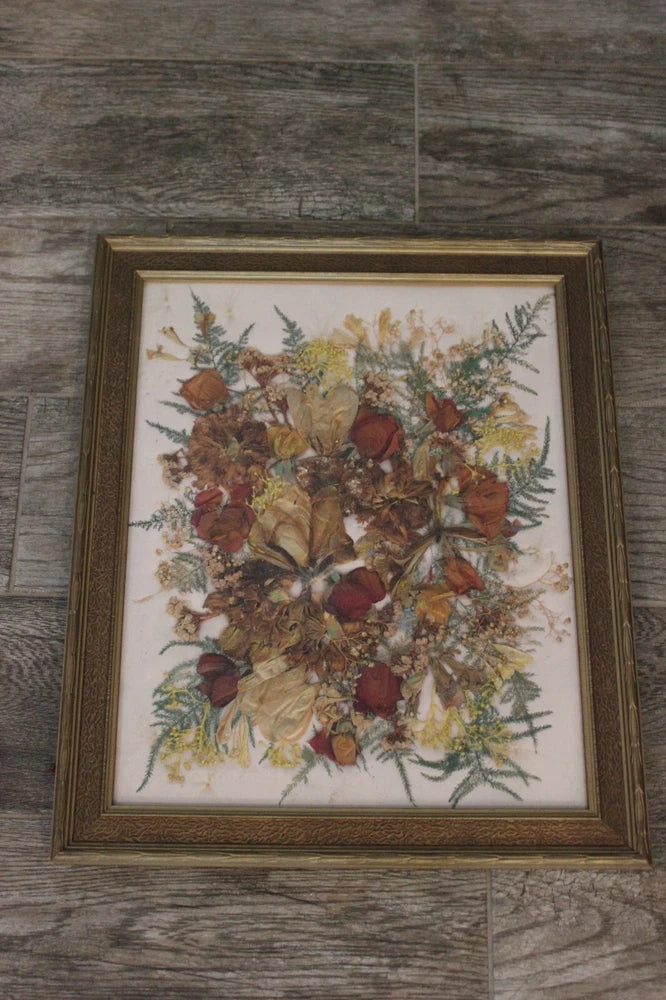 Framed pressed dried flowers with roses and ferns in a gold brown picture frame