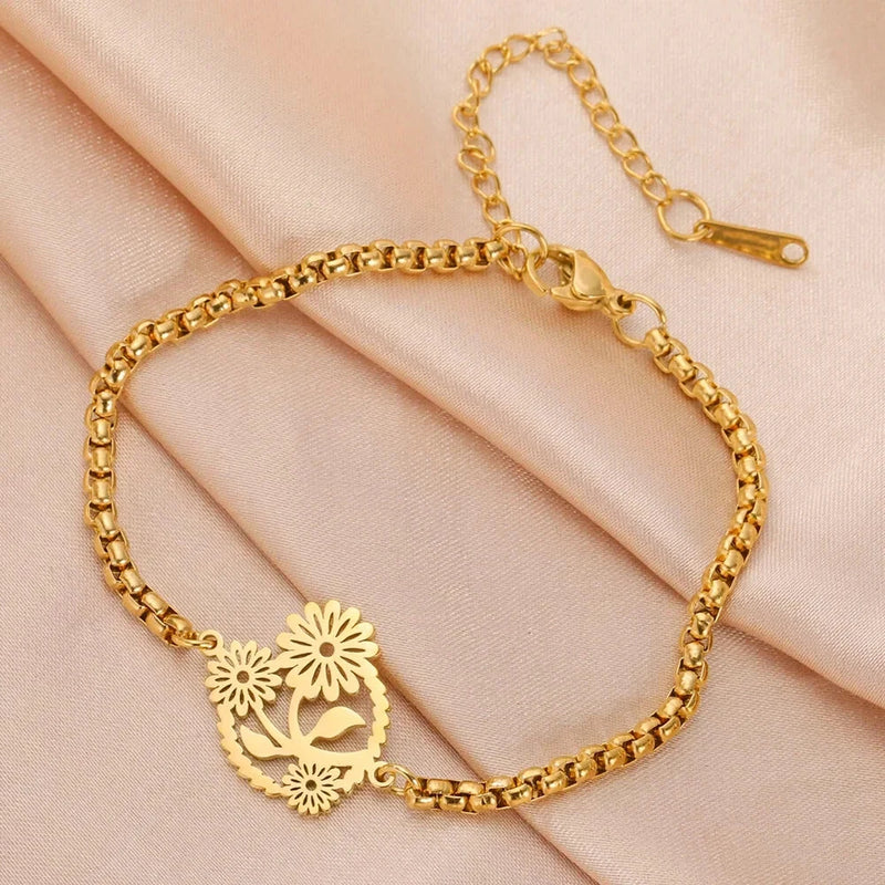 Gold-tone stainless steel box chain bracelet with three sunflower charms and small bird detail