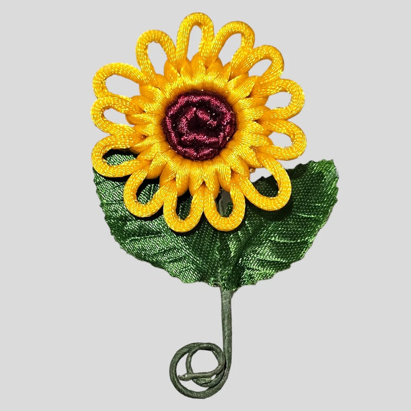 Sunflower macrame lapel pin with yellow petals, purple center, and green leaf