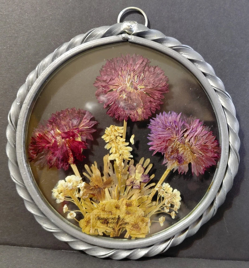 Round pewter frame suncatcher with pressed dried flowers: pink, purple, yellow