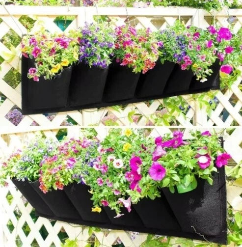 Black hanging grow bag with multiple fabric pockets for wall planting, filled with flowers