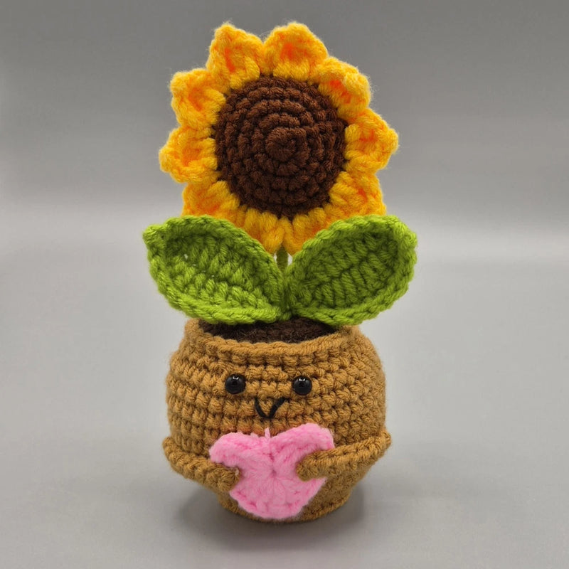 Handmade crochet sunflower amigurumi in a small pot with green leaves and pink flower