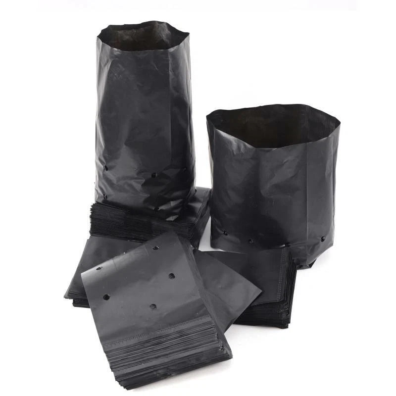 Dark plastic garden grow bags, two upright with stacked folded pouches