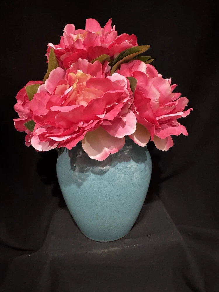 Artificial pink peony arrangement in a blue ceramic vase