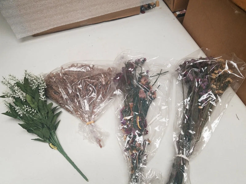 Assorted dried potpourri flower bundles, wrapped in clear plastic with purple blooms