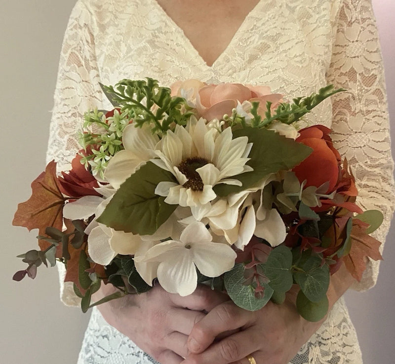 Faux floral bridal bouquet with white flowers, red and pink accents, and green leaves