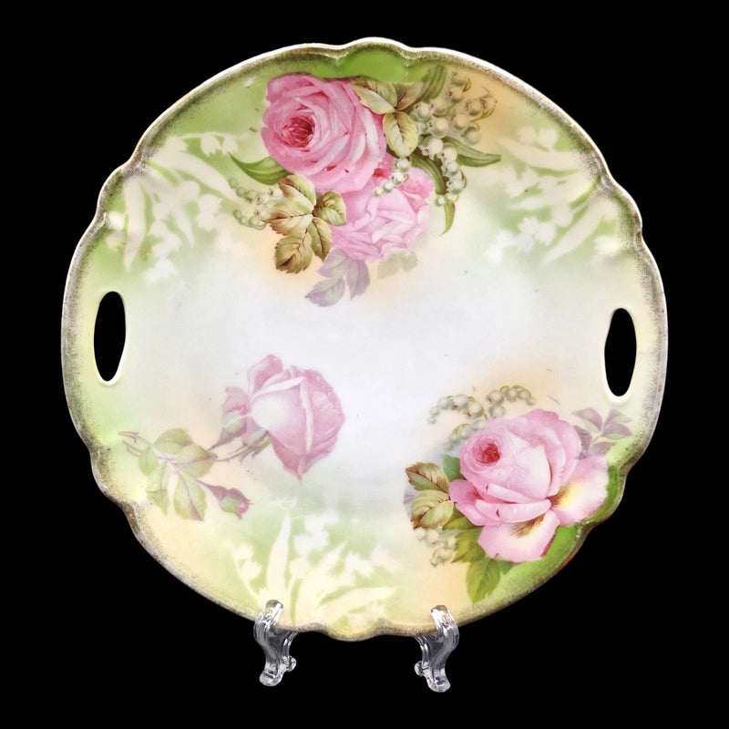 Vintage porcelain cake plate with handles, pink roses and green leaves, gold trim.