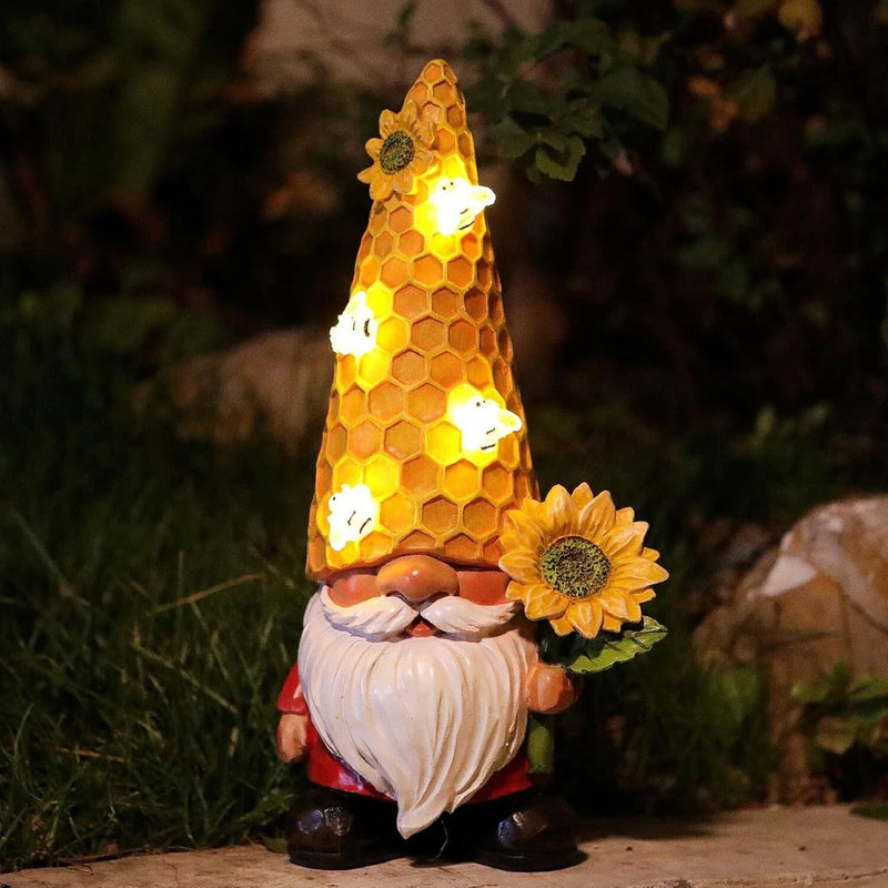 Solar light garden gnome statue with glowing honeycomb hat, white beard, holding sunflower