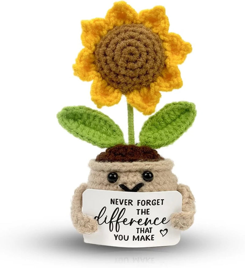 Crochet sunflower decor: yellow flower, green leaves; plush holds sign 'Never forget difference'.