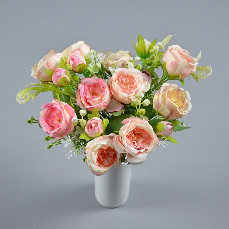 Silk peony bouquet with pink and peach flowers, green leaves, in a white vase