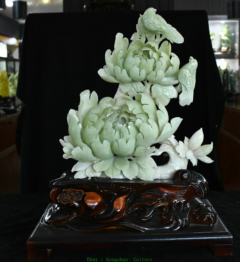 Carved jade peony flower and bird statue on dark wooden base
