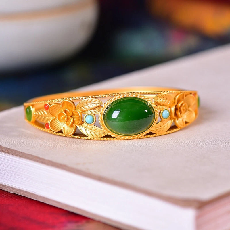 Gold-tone bracelet with green oval gemstone and peony flower inlay details