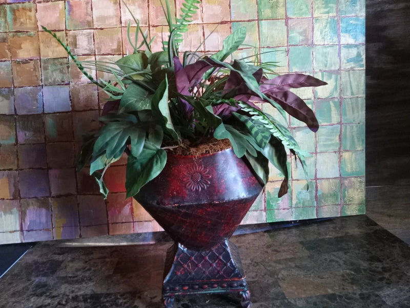 Artificial leaf greenery arrangement in red vase with purple and green leaves