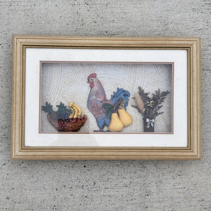 Vintage framed folk art wall piece with rooster, fruit, and dried flowers in distressed frame